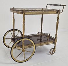 an antique brass serving cart with wheels