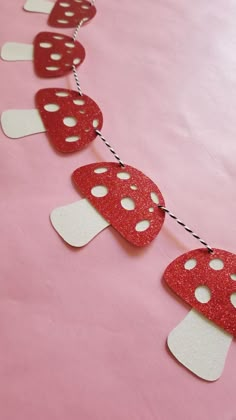 a red and white paper garland with mushrooms on it