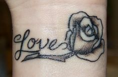 a small wrist tattoo with the word love on it