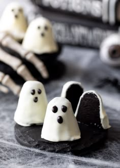 three halloween ghost cookies sitting on top of a table