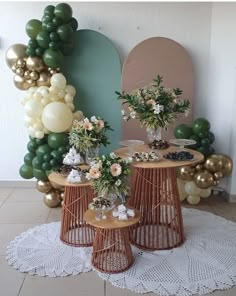 three tables topped with vases filled with flowers and greenery on top of a white doily