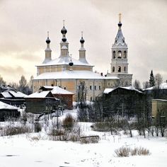 an old church with three steeples stands in the middle of a snow covered field