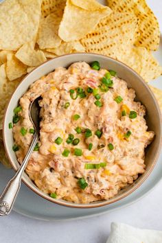 a bowl of dip with chips on the side