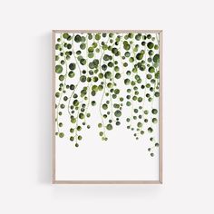 an art print with green leaves hanging on the wall