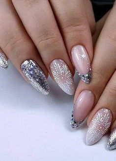 a woman's nails with white and silver decorations