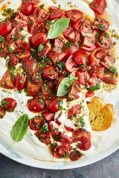 a white plate topped with sliced tomatoes and cream cheese