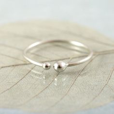 "Inspired by tiny pebbles on a beach. Elegant and minimalist little silver ring with a cute pair of dots - little buds where the ring comes together. It is therefore open and slightly adjustable, but since it is made from Argentium silver very sturdy. It is 1 mm thick and the tiny drops about 1.50 and 2 mm. As they are made by hand (my hand) the drops vary ever so slightly in size and shape. Goes really well with my dew stacking rings: http://etsy.me/1E9ySFC Don't forget to choose your size. If Slim Ring, Silver Stacking Rings, Jewellery Ideas, Jewelry Studio, Argentium Silver, Gift For Girlfriend, Stacking Ring, Jewellery Making, Silver Jewellery