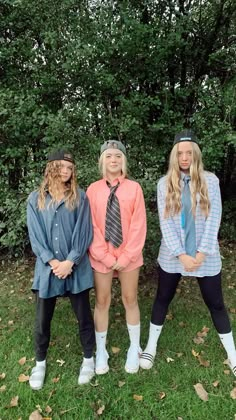 three young women standing next to each other in front of trees and grass with their hands on their hipss