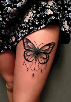 a woman's thigh with a butterfly tattoo on the side of her leg,