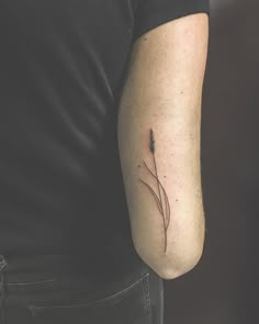 a man's arm with a single flower tattoo on the left side of his arm