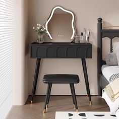 a black vanity table with a mirror and stool next to it in a bedroom setting