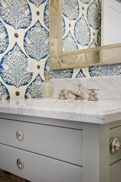 a bathroom vanity with blue and white wallpaper