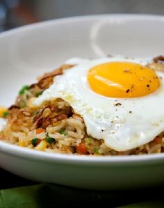 a white bowl filled with rice and an egg