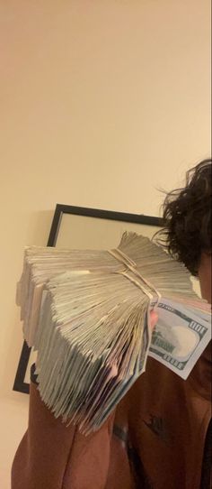 a man holding up a stack of money in front of his face