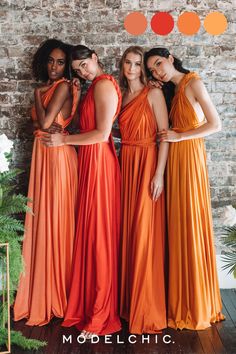 three women in orange dresses standing next to each other with their arms around one another