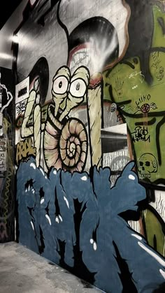 graffiti is painted on the side of a wall in an alleyway with other street art