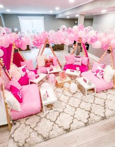 a room with pink furniture and balloons on the ceiling, in front of a white rug