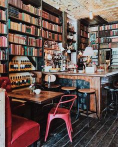 an old fashioned library with many bookshelves full of books and chairs in it