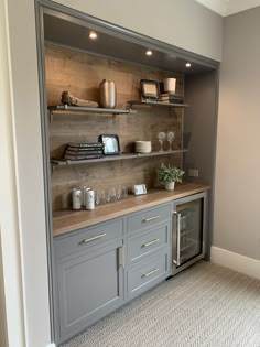 a kitchen with gray cabinets and shelves filled with wine glasses