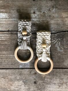 two wooden rings with tassels on top of a wooden table next to each other