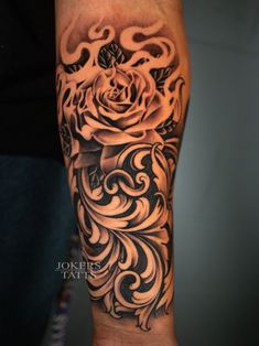 a man's arm with a rose tattoo design on the forearm and hand, in black