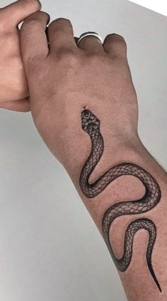 a man's arm with a snake tattoo on it