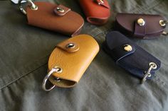 four leather key fobs sitting on top of a bed