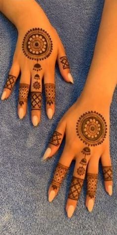 two hands with henna tattoos on them