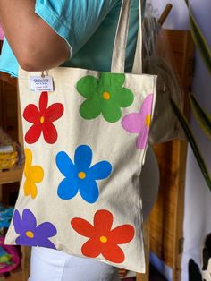 a woman is holding a bag with flowers on it