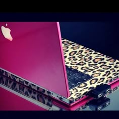 an open laptop computer sitting on top of a leopard print case