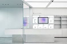 an empty room with glass walls and white shelves on the wall, containing electronic devices