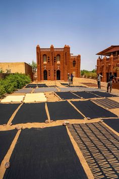 some people are walking around in front of an old brick building that is being constructed