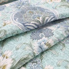 the blue and green floral print is on top of the bedding sheet coverlet