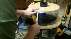 a man is working on a table with a drill and some other tools in it