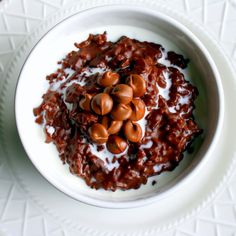 a bowl filled with some kind of food on top of a white plate and sauce