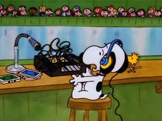 a cartoon character sitting at a desk with headphones on