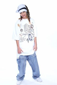 a young boy wearing a white shirt and jeans standing in front of a white background