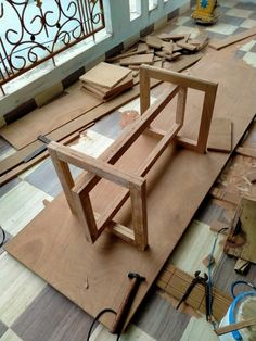 a wooden table sitting on top of a hard wood floor next to a metal railing