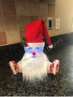 a stuffed santa clause sitting on top of a counter