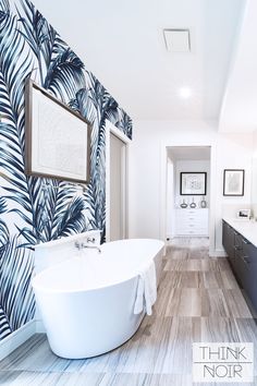 a bathroom with blue and white wallpaper, large bathtub in the foreground