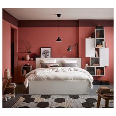 a bedroom with red walls and white bedding in the center is decorated with bookshelves