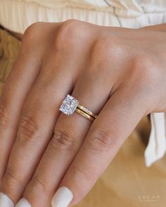 a woman's hand with two gold rings and a diamond ring on her finger