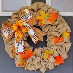 a burlock wreath with orange and yellow leaves on the front door's side