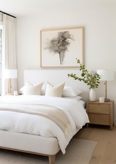 a bed with white linens and pillows in a bedroom next to a large window