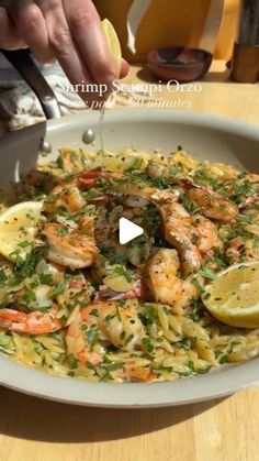 shrimp and pasta with lemon wedges in a white bowl