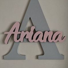 a wooden sign that says ariaa on the side of a white and gray wall