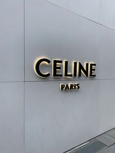 a sign that says celline paris on the side of a building with a sidewalk in front of it