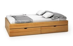 a bed with two drawers underneath it and pillows on the top one, next to another