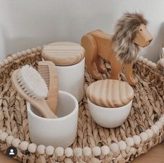 a wooden toy lion sitting on top of a table next to bowls and brushes