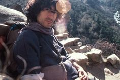 a man sitting on top of a rocky hillside